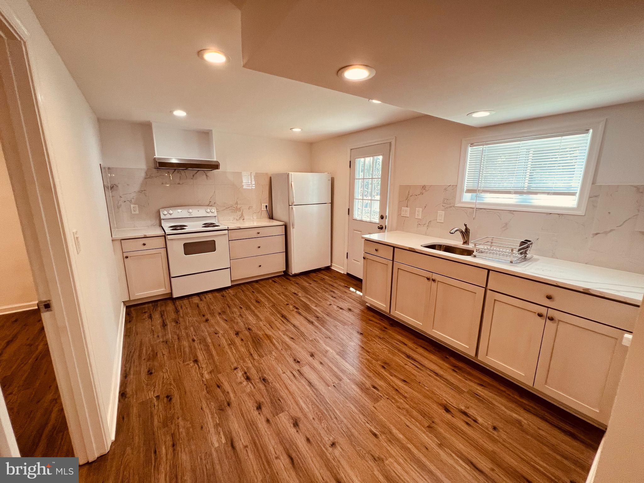 11814 Mentone Road Silver Spring, MD 20906 - Photo 3 of 12 a kitchen with cabinets a sink and wooden floor
