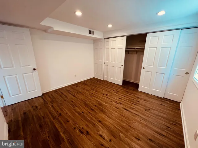 a view of empty room with wooden floor and electronic appliances
