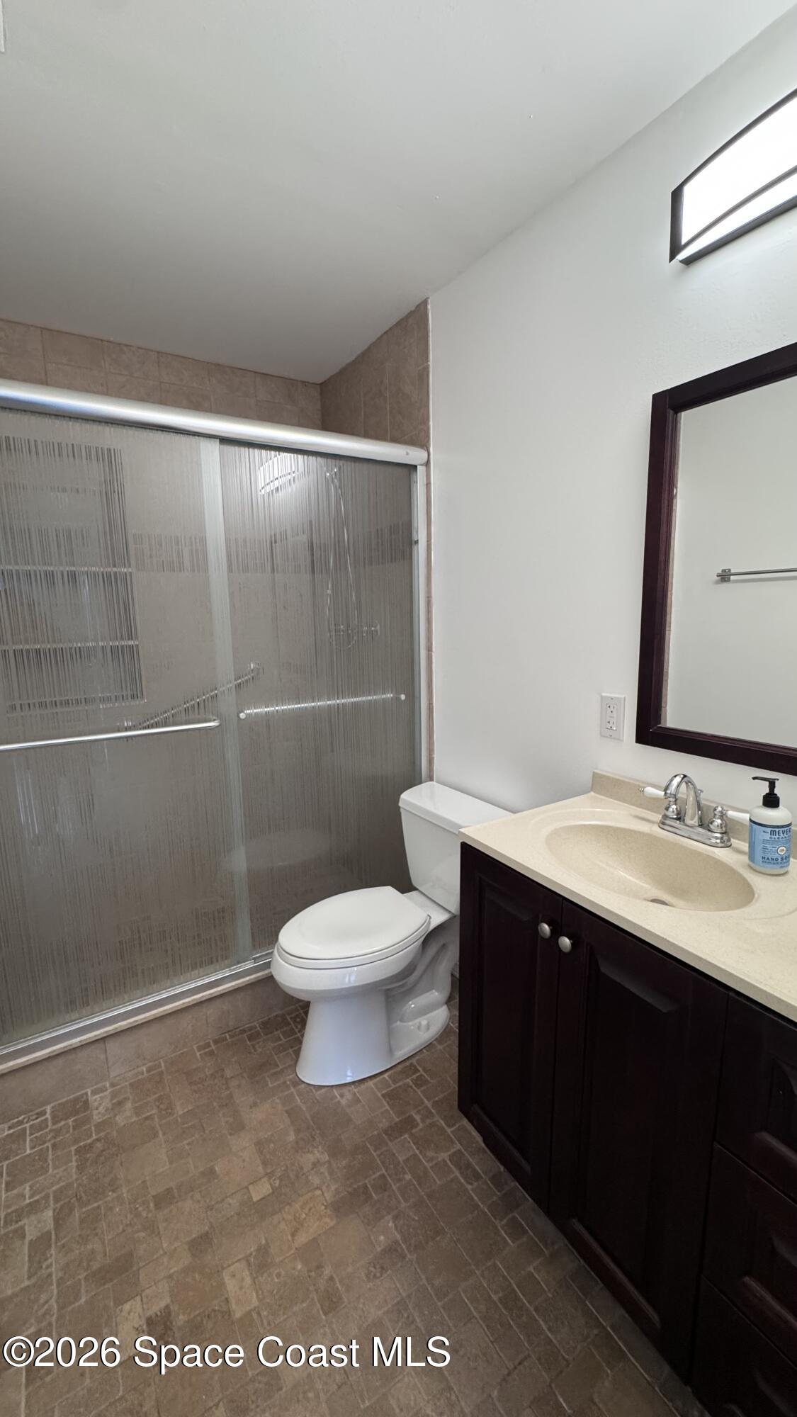 2137 Laden Road Melbourne, FL 32935 - Photo 16 of 23 a bathroom with a sink a toilet and a mirror
