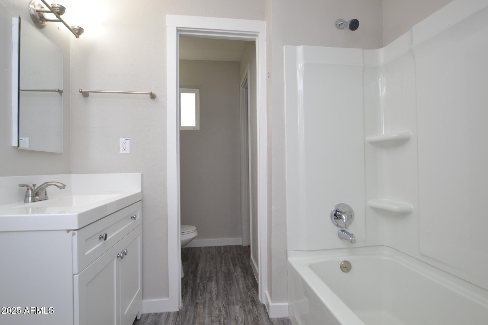 2202 West Devonshire Avenue, Unit 3 Phoenix, AZ 85015 - Photo 14 of 16 a bathroom with a tub sink vanity and a mirror