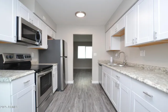 a kitchen with stainless steel appliances granite countertop a stove a sink and a microwave