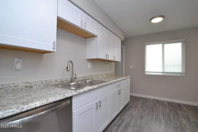 a kitchen with granite countertop a sink and cabinets