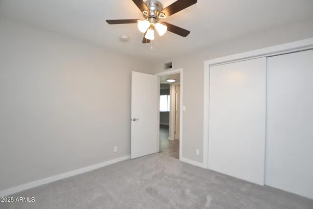 a view of an empty room and a ceiling fan