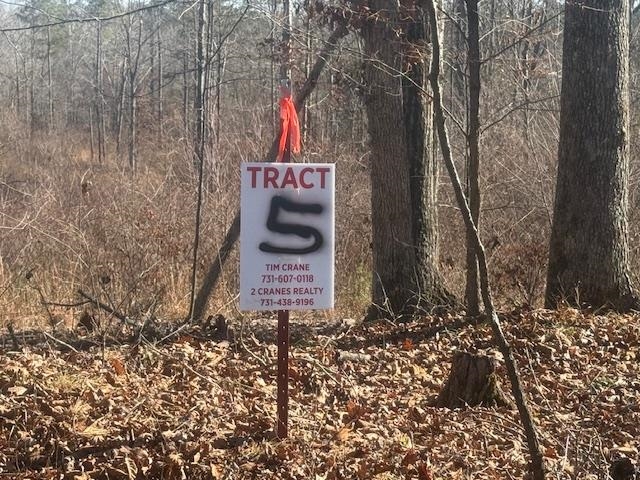 a sign board with a tree in the background