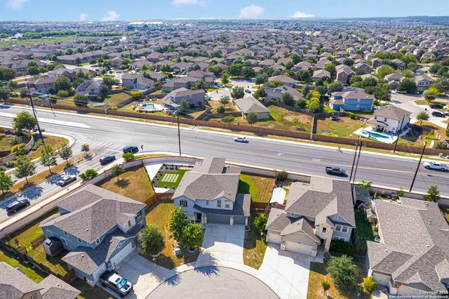 an aerial view of a house with a yard and lake