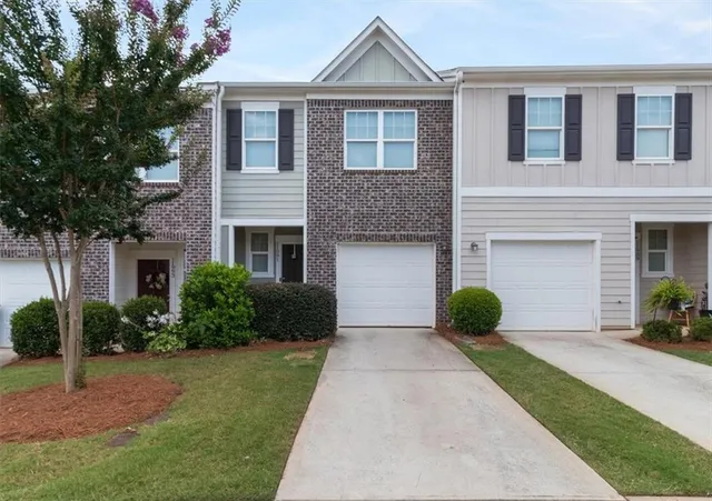 a front view of a house with garden and plants