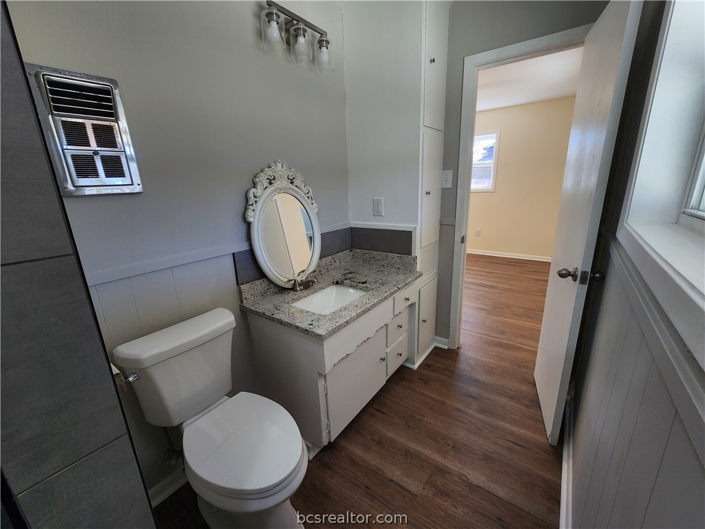 1405 Broadmoor Drive Bryan, TX 77802 - Photo 11 of 27 a bathroom with a granite countertop toilet sink and mirror