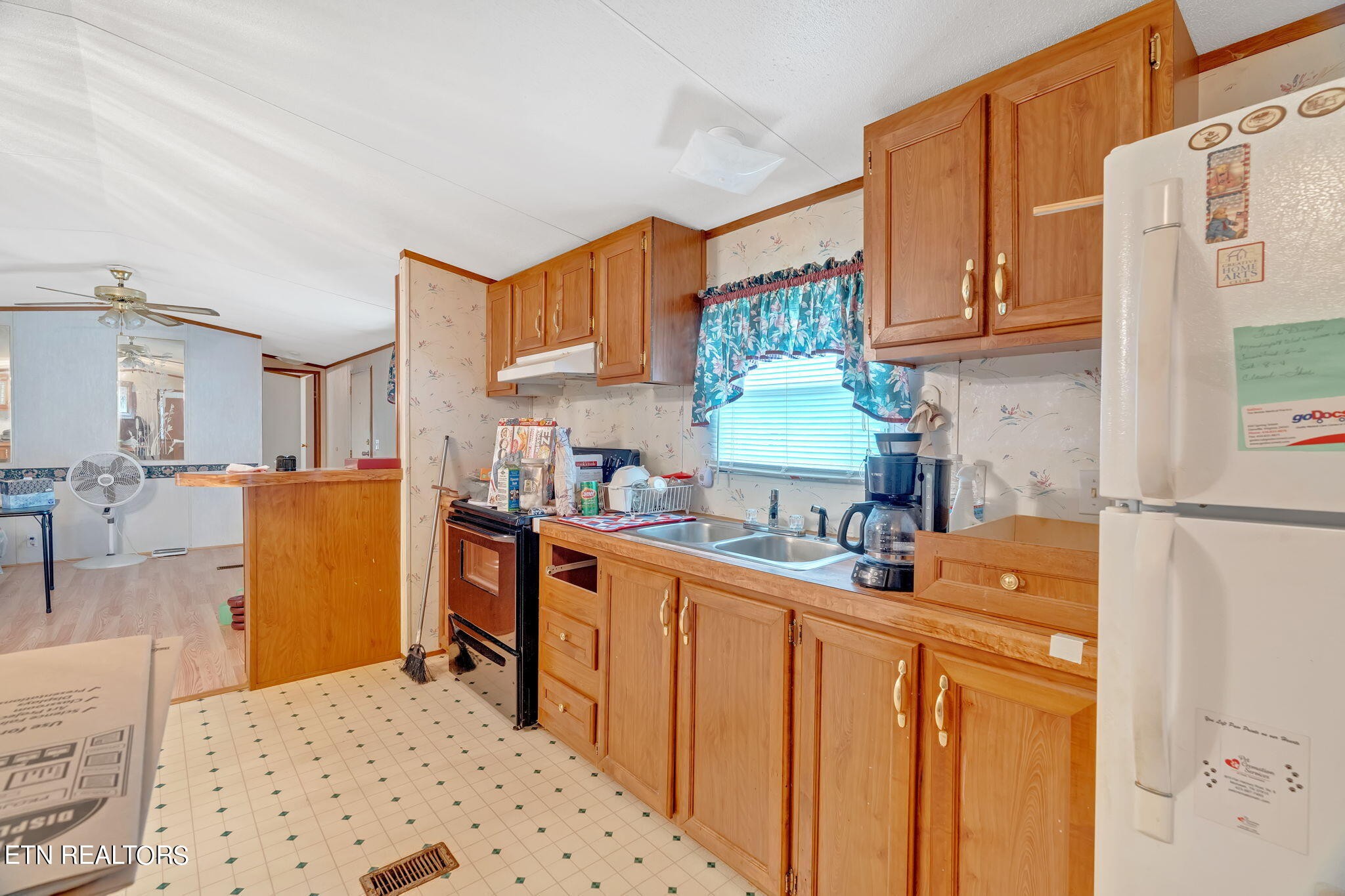 480 Oasis Road Bulls Gap, TN 37711 - Photo 11 of 16 a kitchen with a refrigerator a stove a sink dishwasher and wooden cabinets with wooden floor