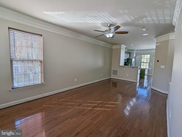 a view of a livingroom with wooden floor and a ceiling fan