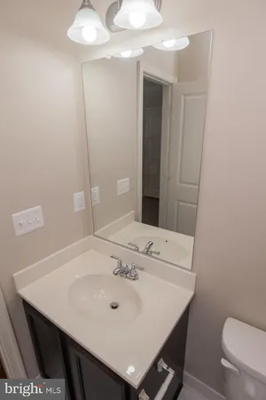 a bathroom with a sink a toilet and a mirror