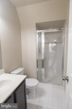 a bathroom with a granite countertop toilet a sink and shower