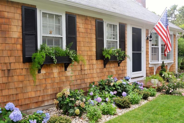 10 Howard Road Harwich, MA 02645 - Photo 3 of 29 a house with a lot of flower plants in front of house