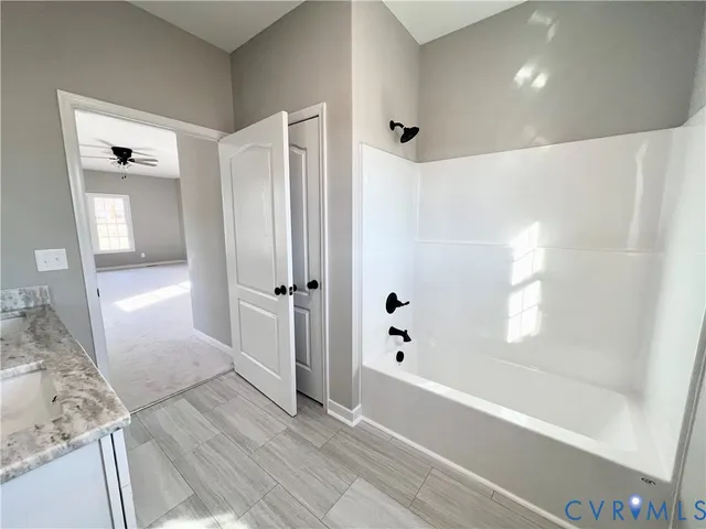a bathroom with a granite countertop toilet sink and mirror