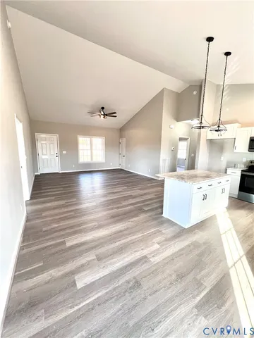 a kitchen with stainless steel appliances granite countertop a stove a sink dishwasher and a refrigerator with wooden floor