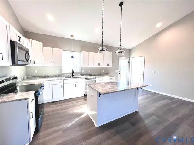a kitchen with kitchen island granite countertop wooden floors and wide window