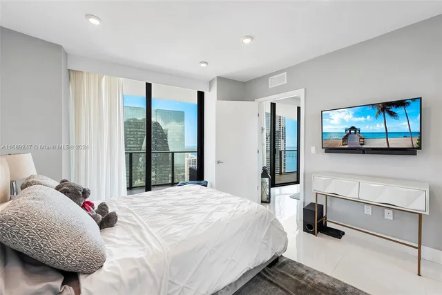 a bedroom with a bed a mirror and a large window