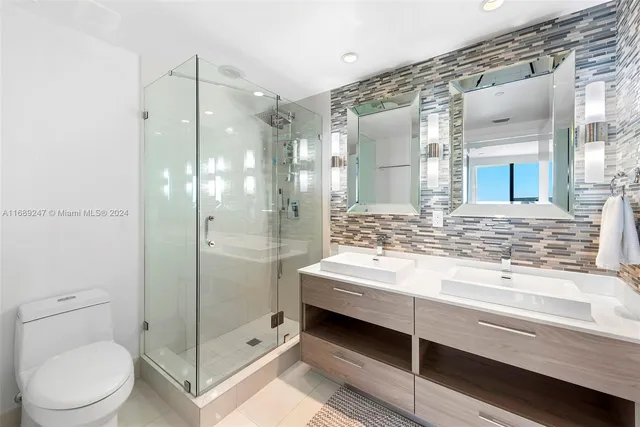 a bathroom with a bathtub shower sink vanity and toilet