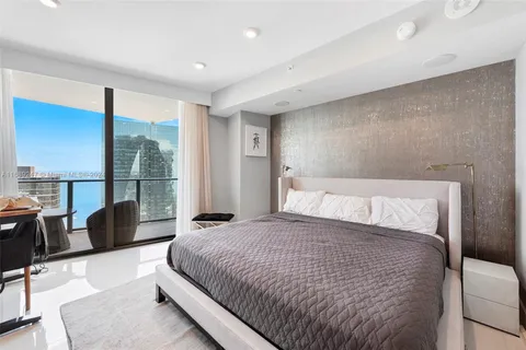 a large bedroom with a bed and glass window