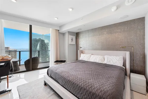 a large bedroom with a bed and glass window