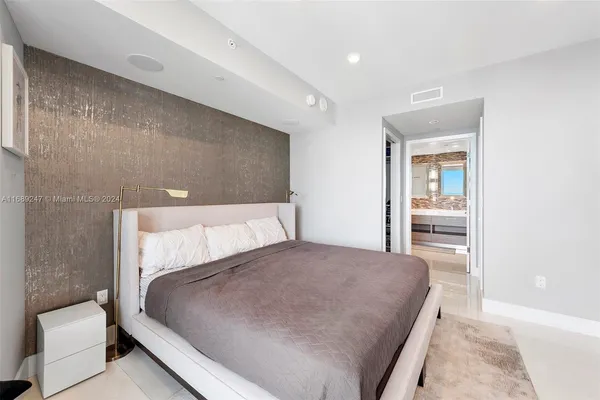 a large bedroom with a bed and wooden floor