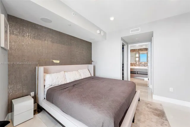 a large bedroom with a bed and wooden floor