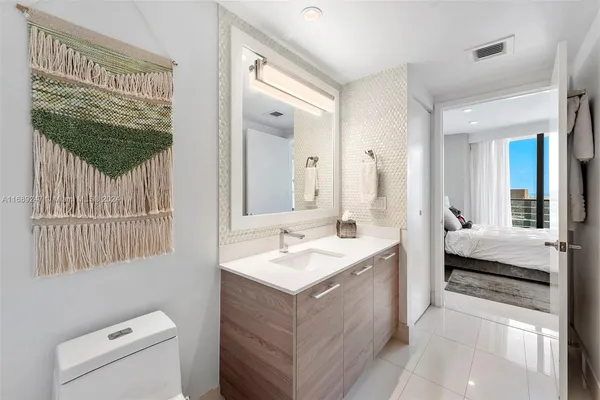 a en suite bathroom with a granite countertop sink and a mirror