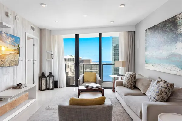 a living room with furniture and floor to ceiling windows