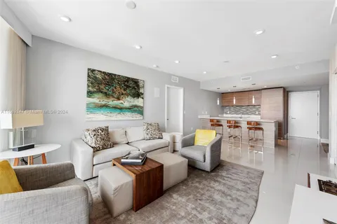 a living room with lots of furniture and view of kitchen