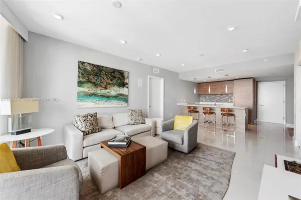 a living room with lots of furniture and view of kitchen