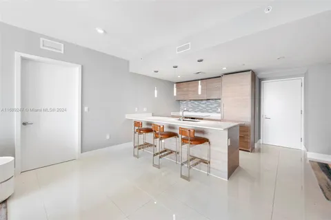 a room with stainless steel appliances kitchen island granite countertop furniture and a refrigerator