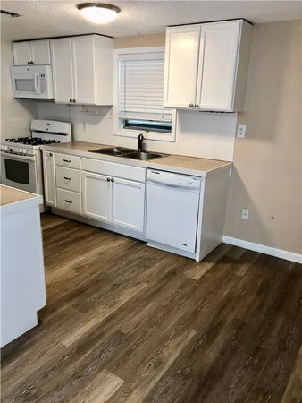 a kitchen with stainless steel appliances granite countertop a sink a stove and cabinets
