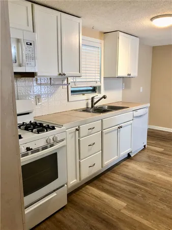 a kitchen with stainless steel appliances granite countertop a sink a stove and cabinets