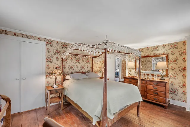 a bedroom with a bed mirror and a window