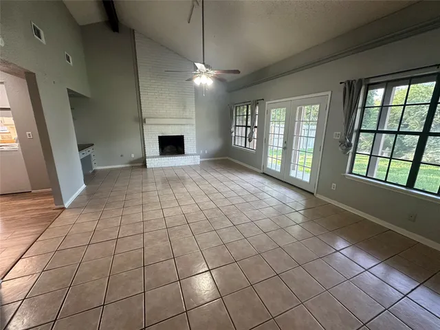 a view of an empty room with a fireplace and a window