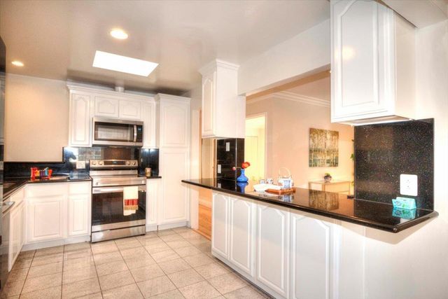 a kitchen with stainless steel appliances granite countertop a stove and a sink