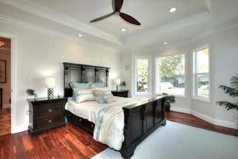 a large bedroom with a bed and wooden floor