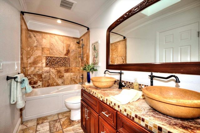 a bathroom with a granite countertop sink mirror toilet and bathtub
