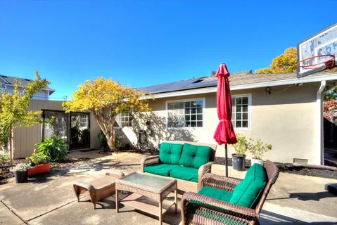 a view of a house with backyard sitting area and garden