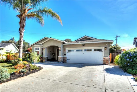 a front view of a house with a garden and yard