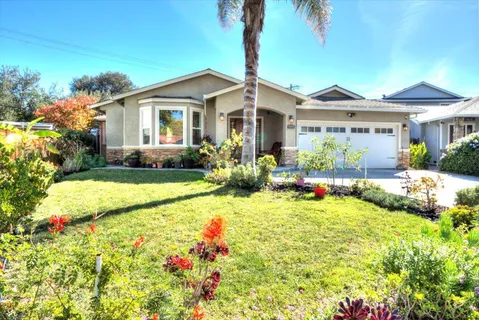 a view of a house with backyard sitting area and garden