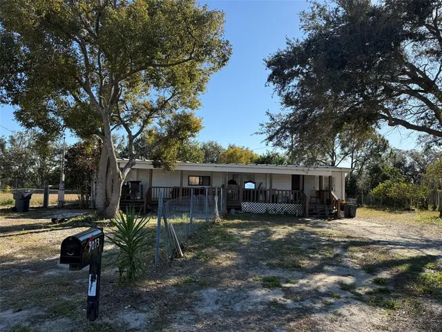 a view of house with backyard and trees