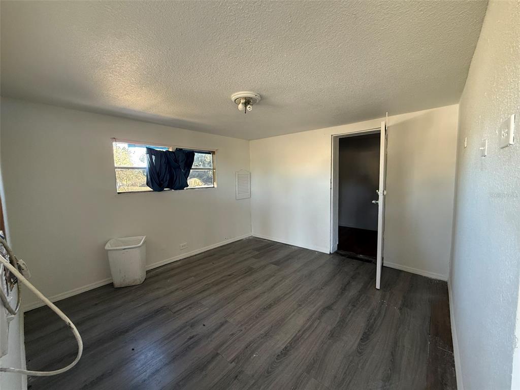 9013 Burr Drive Polk City, FL 33868 - Photo 4 of 20 a view of an empty room with wooden floor and a window