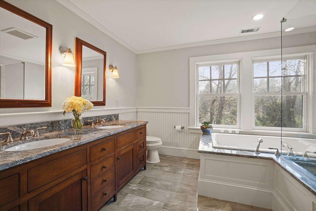 111 Tower Road Lincoln, MA 01773 - Photo 20 of 30 a bathroom with a granite countertop sink mirror and a large window