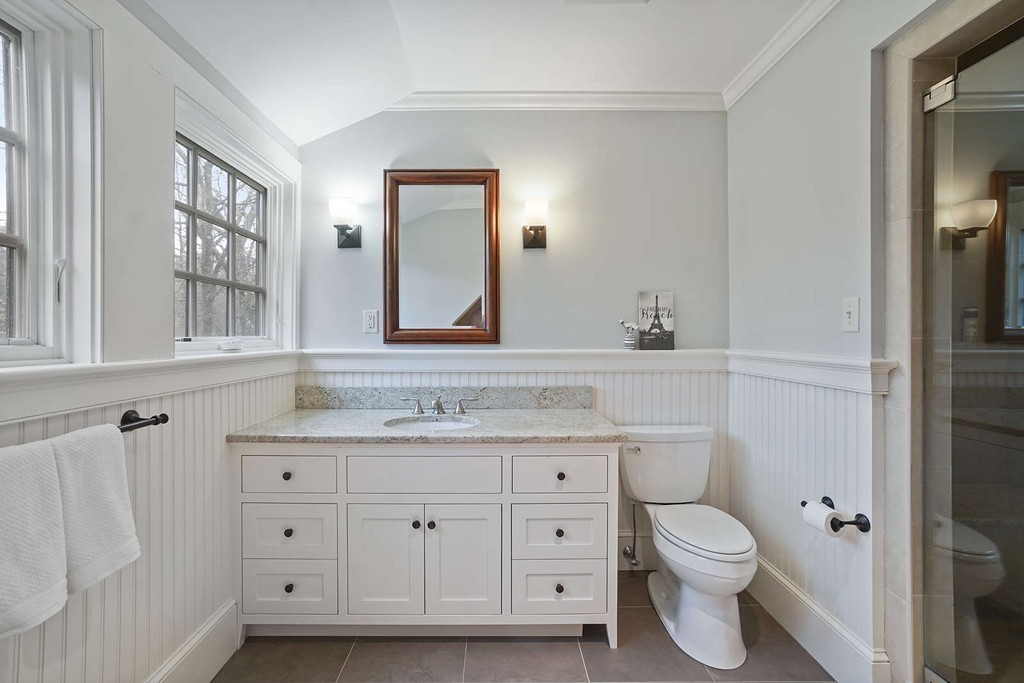 111 Tower Road Lincoln, MA 01773 - Photo 25 of 30 a bathroom with a granite countertop toilet sink and mirror