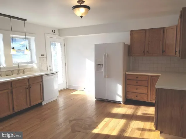 a view of a kitchen with wooden cabinet and a large window