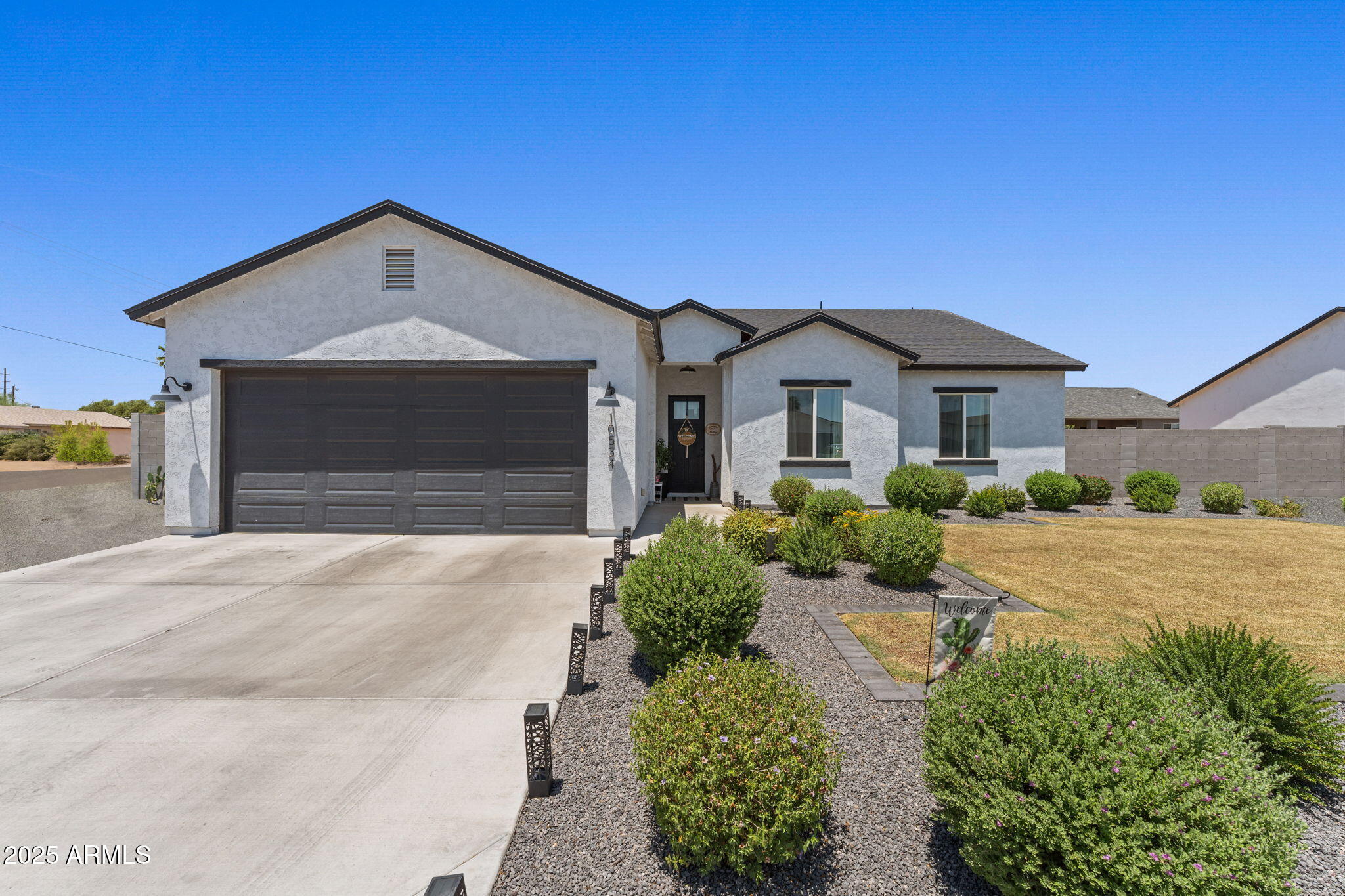 10534 East Butte Street Apache Junction, AZ 85120 - Photo 3 of 51 a front view of a house with a yard and garage