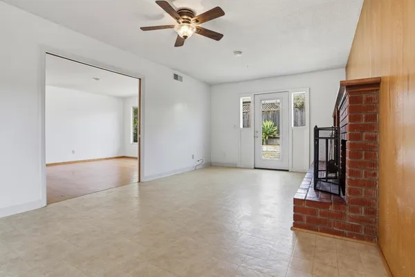 a view of an empty room with closet and a window