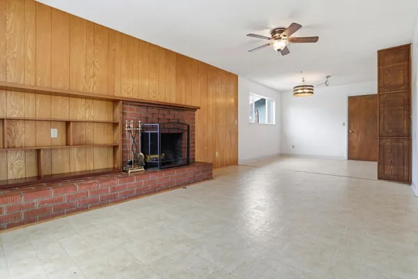 an empty room with windows and fireplace