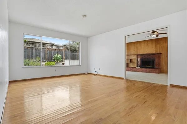 a view of an empty room with a window and fire place