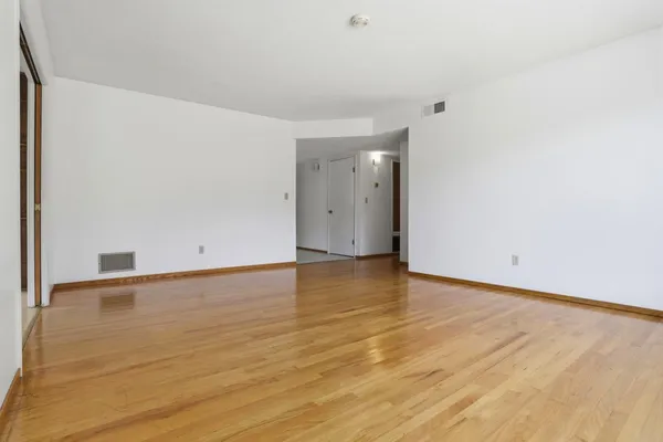 a view of an empty room with wooden floor